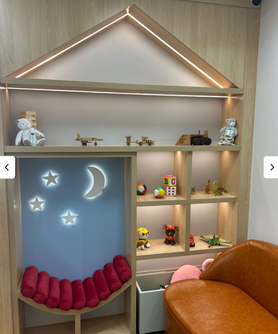Cantinho lúdico do consultório com brinquedos e iluminação de lua e estrelas